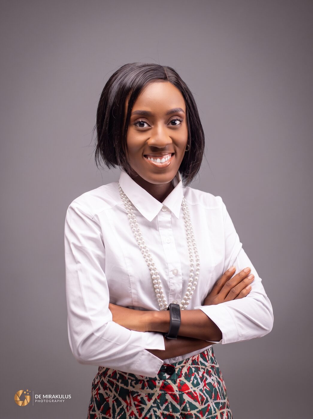 Corporate portrait of a woman in a white shirt, arms folded