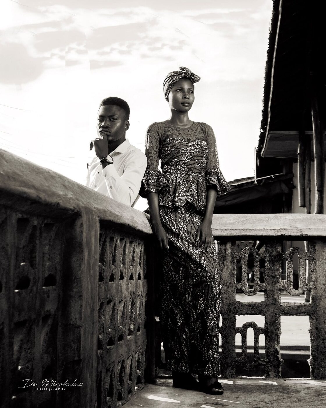 Black and white documentary portrait of two people on a balcony