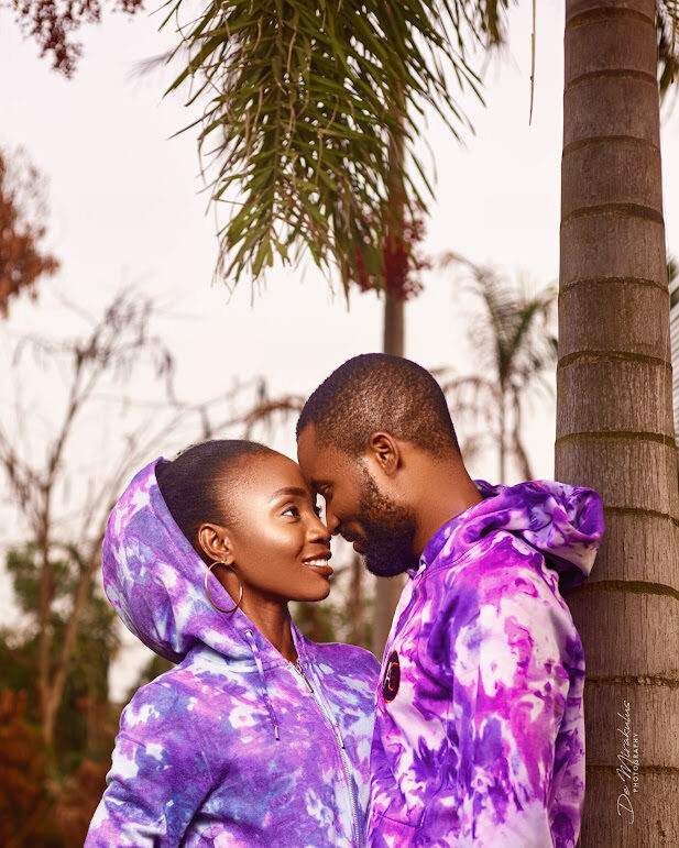 Couple touching foreheads under palm trees